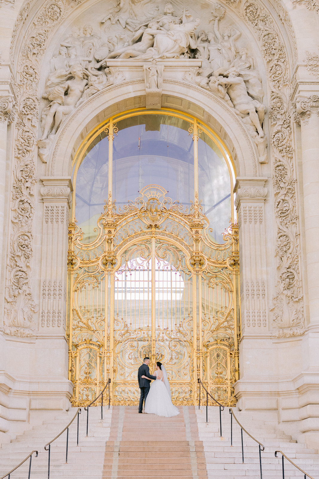 Couple celebrating their love in front of grand golden door in Paris